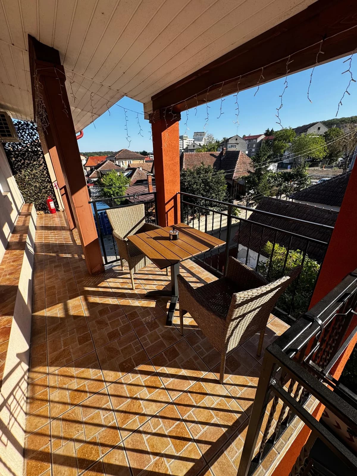 Balconul acoperit cu masa si scaune de rachita