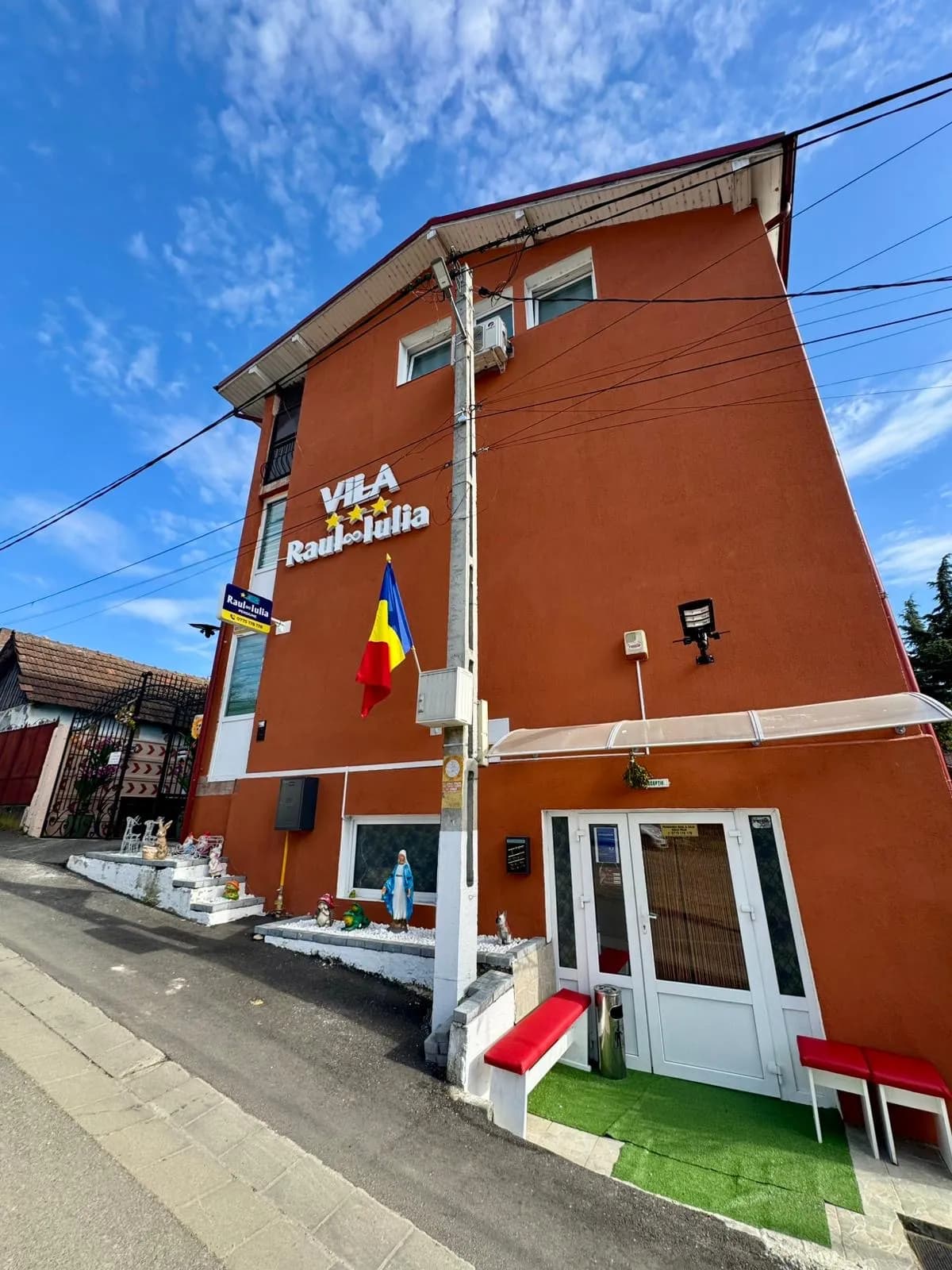 Fatada pensiunii cu firma si steagul