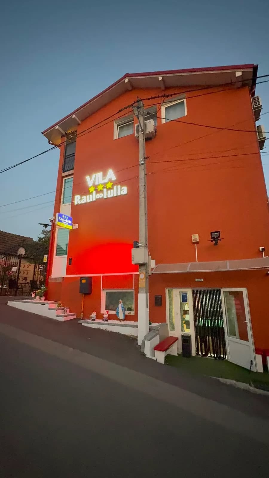 Fatada vilei seara cu firma luminata